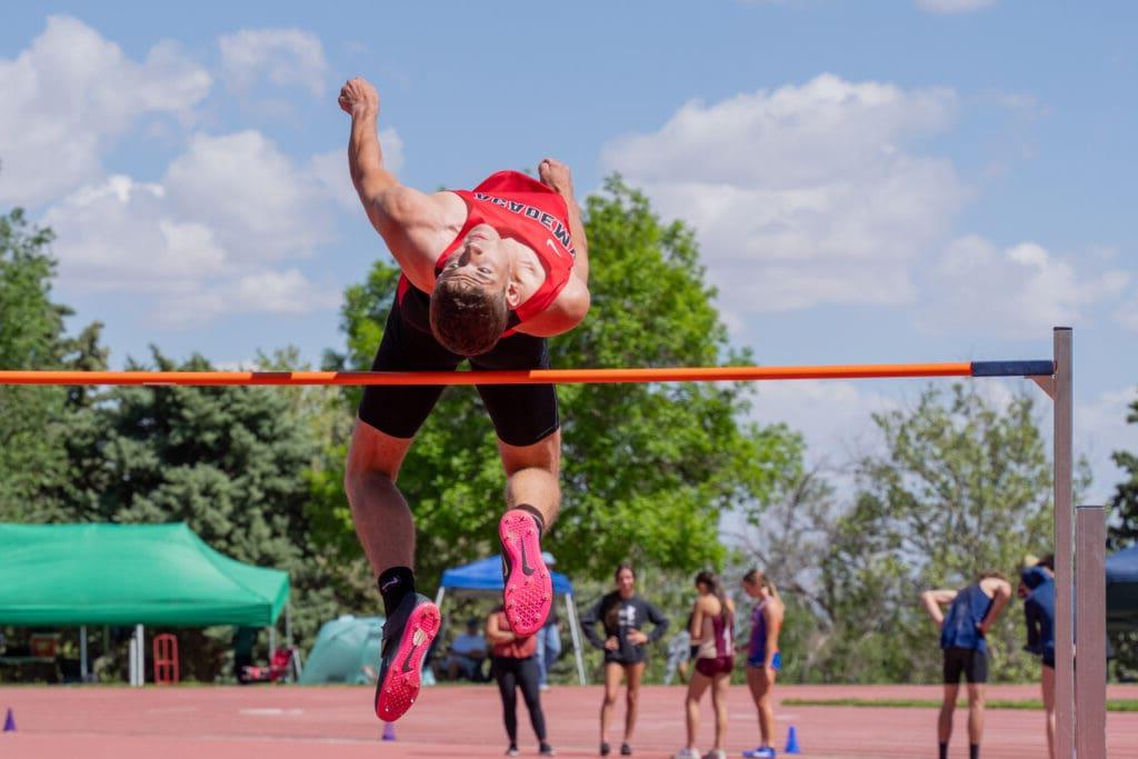 Athlete performing high jump at outdoor track meet.